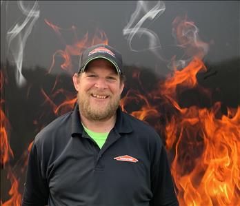 Project manager Nate Standing against fake fire backdrop