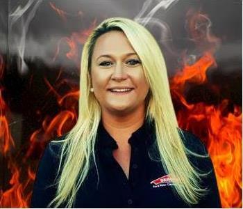 Crew member Dawn standing against fake fire backdrop