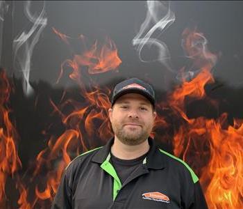 Project manager Eric Standing against fake fire backdrop