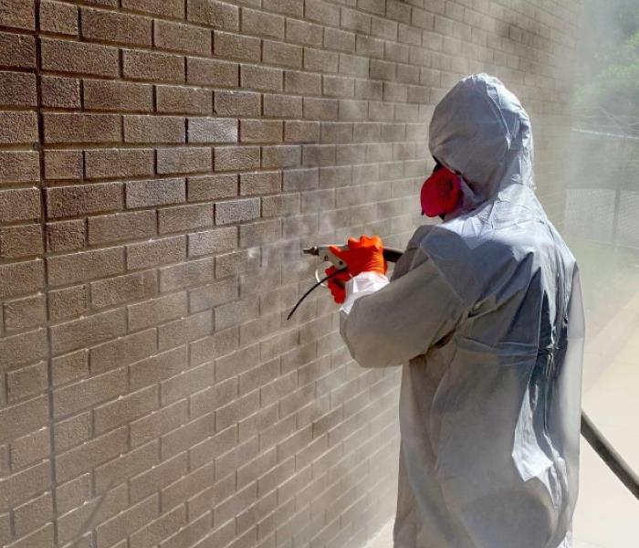 SERVPRO project manager soda blasting a brick wall
